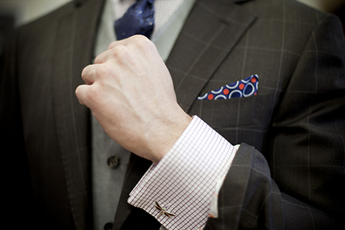 рука в рубашке с запонкой-стрекозой, клетчатый иджак и платочек